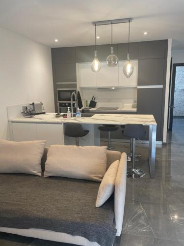 un salon avec un canapé et une cuisine dans l'établissement Appartement moderne et cosy, à Marseille