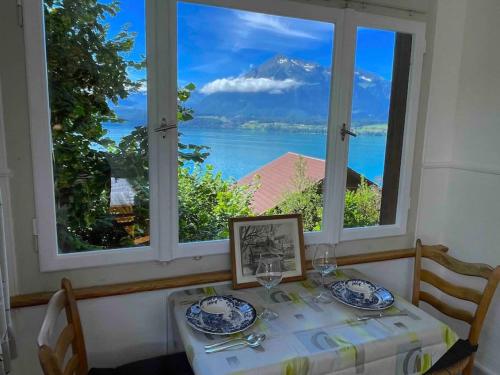 a table with a view of a mountain from a window at SwissHut Stunning Views Alps Lake Apart Kilinger in Oberhofen am Thunersee
