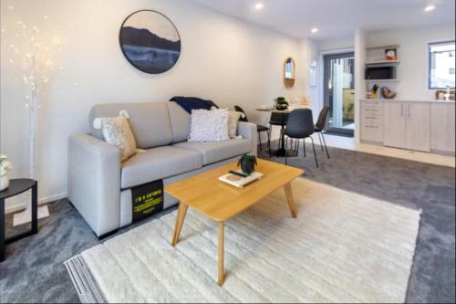 un salon avec un canapé et une table dans l'établissement Lovely 2 bed 2 bath, à Christchurch