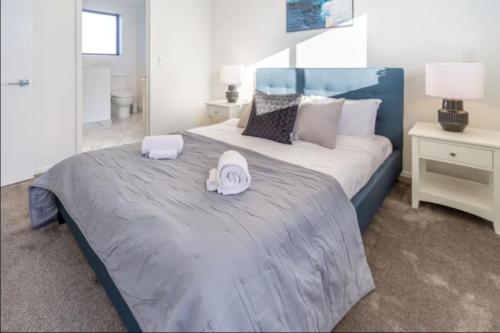 une chambre avec un grand lit avec deux serviettes dessus dans l'établissement Lovely 2 bed 2 bath, à Christchurch