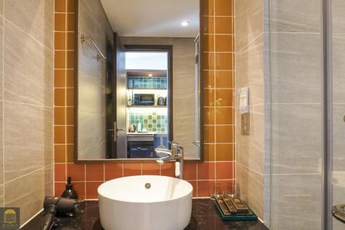 a bathroom with a sink and a mirror at Apec Mandala de Suite Mũi Né in Mui Ne