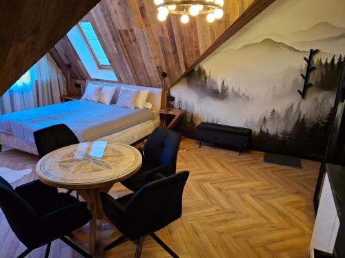 a bedroom with a bed and a table and chairs at Zwierzyniecka Residence in Zakopane