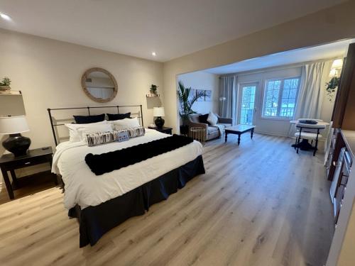 a bedroom with a large bed and a living room at Newly Renovated Ski-In Ski-Out 1-Bedroom Condo with Pool, Gym, Sauna by Horseshoe Valley in Edgar