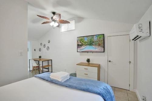 a bedroom with a bed and a tv on the wall at Tropical Oasis Studio w Pool in Fort Lauderdale