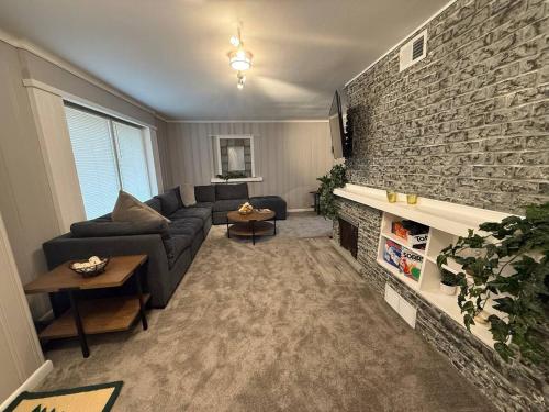 a living room with a couch and a brick wall at Newly Renovated Gem Fenced Backyard 2 Full Baths in Allen Park