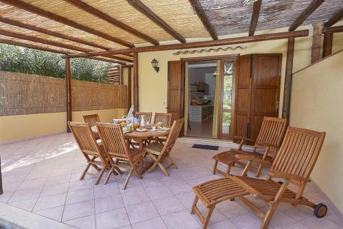 a patio with a table and chairs on a patio at Villa Uzzo by Sicily Travelling Villas in Scopello