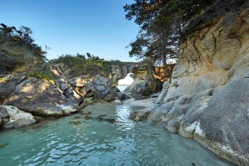 a river in a rocky area with water and trees at Au pied du GR 34 in Fouesnant