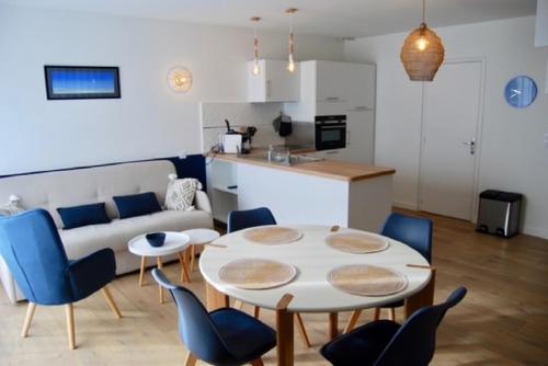 a kitchen and a living room with a table and chairs at Au pied du GR 34 in Fouesnant