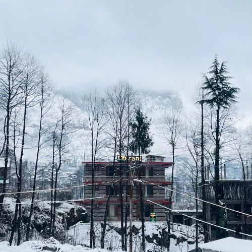 a building in the middle of a snow covered forest at Ekaant Stays - Manali in Manāli