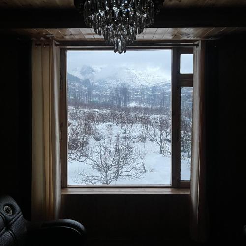 a window with a view of a snow covered field at Ekaant Stays - Manali in Manāli