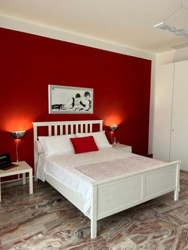 a bedroom with a white bed with a red wall at Residenza Muraca in Lamezia Terme