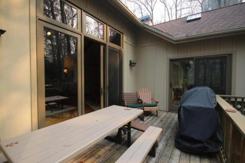 a patio with a bench and a table on a deck at Pine Hill in Rosman
