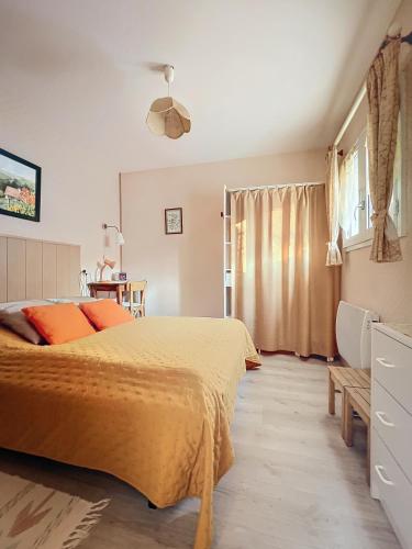 ein Schlafzimmer mit einem gelben Bett und einem Fenster in der Unterkunft Maison des Bains in Allevard