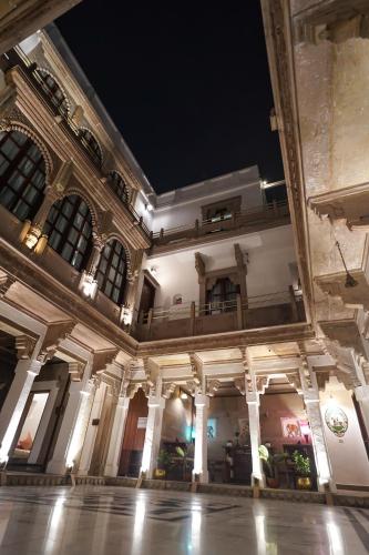 a large building with columns and ceilings at night at Guleria Kothi at Ganges in Varanasi