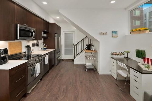 a large kitchen with wooden cabinets and a staircase at Perch - Centro house F in Seattle