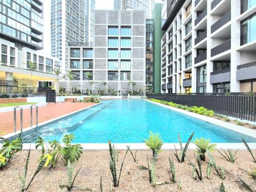 a large swimming pool in the middle of some buildings at Olympic Park Escape 2BR w Gym, Pool & Free Parking in Sydney