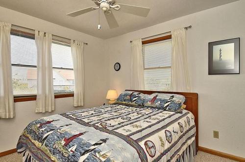 a bedroom with a bed and a ceiling fan at OH1213- Barefoot Babies in Corolla