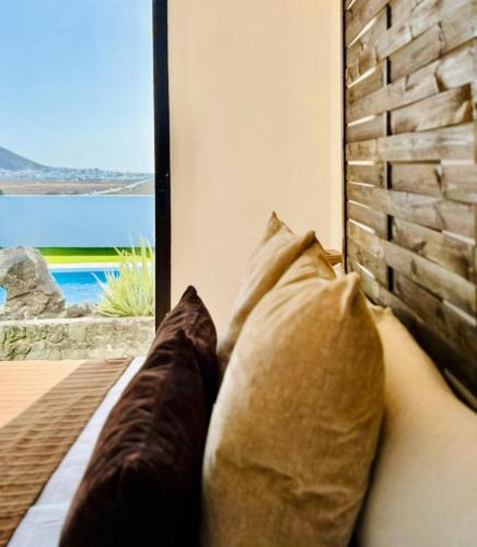 two pillows sitting on a couch in front of a window at Canaryislandshost l Olympica in Teguise