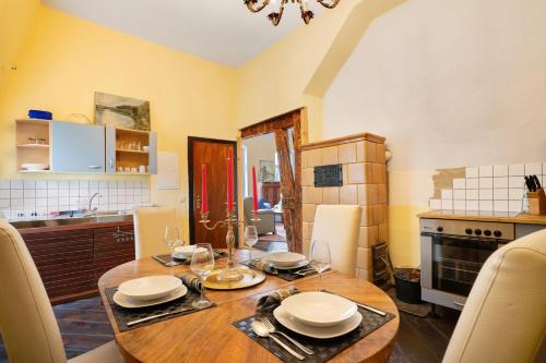 a kitchen with a wooden table with plates and wine glasses at Wohnen Im Alten Rittergut - Calau in Calau