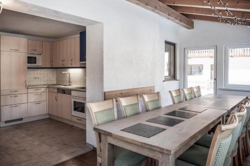 a kitchen with a wooden table and chairs at Ferienhaus Rehhaus in Holzgau