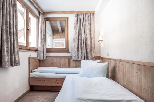 two beds in a room with two windows at Ferienhaus Rehhaus in Holzgau
