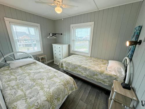 a bedroom with two beds and two windows at KH4117- Beach Balm in Kitty Hawk