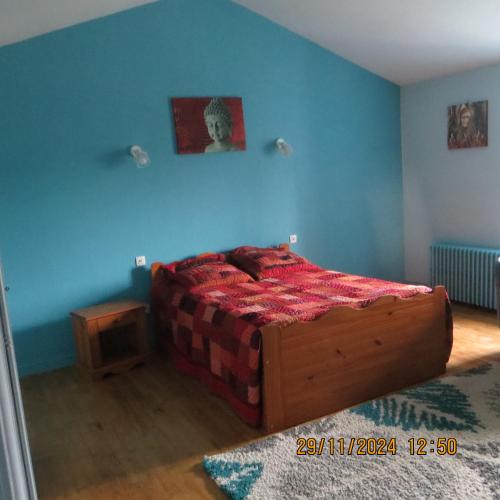 a bedroom with a bed and a blue wall at les bleuet in Cours