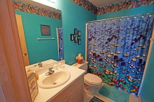 a bathroom with a sink and a shower curtain at WH1020- Crab Quarters in Corolla