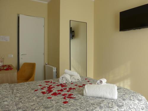 a bedroom with a bed with red roses on it at La Villetta nel Parco in La Giustiniana