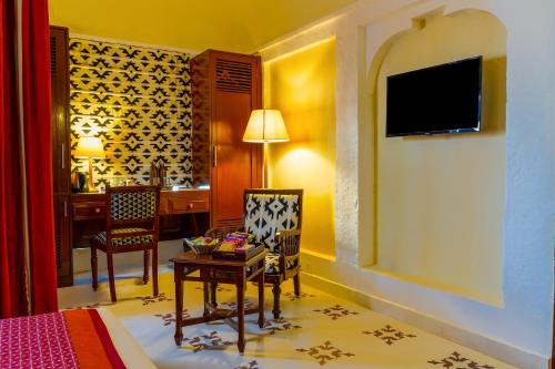 a hotel room with a bed and a desk and a table at Guleria Kothi at Ganges in Varanasi