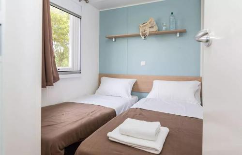 deux lits dans une chambre aux murs bleus dans l'établissement Domaine Résidentiel de Plein Air Le Port de la Chaine, à Pleubian