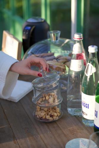 a person putting food in a jar on a table at Al Piglio Maison de Charme Wine & Wellness Resort in Piglio