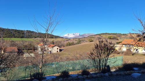 a view of a hill with houses and a mountain at Gîte l'hippocampe in Jarjayes