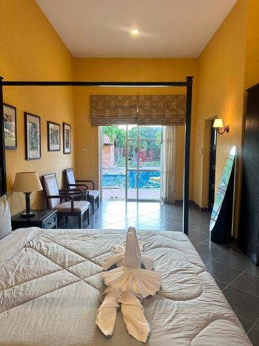 a white robe laying on a bed in a room at วิลล่า พิคทอรี่ in Ban Nong Chap Tao