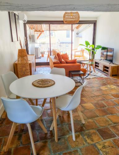 un salon avec une table et des chaises blanches dans l'établissement Nî'douillet-P3 Terrasse et climatisé-coeur de ville, à Nîmes