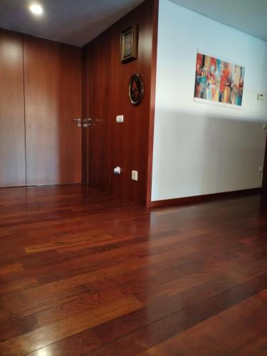 an empty room with wooden floors and a door at Apartamento Centro Guimarães com Vista Panorâmica in Creixomil