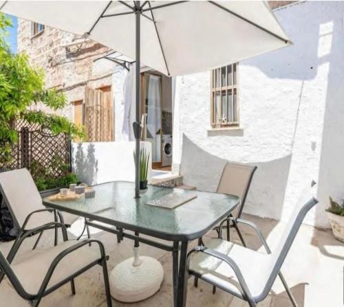 un tavolo e sedie con un ombrellone in un patio di Casa Mondello Sea Life a Palermo