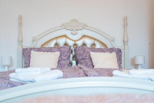 a white bed with purple pillows and a white headboard at EVerLuck město in Loket