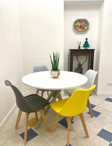 a dining room with a white table and yellow chairs at Casa Mondello Sea Life in Palermo