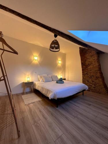 une chambre avec un lit et un mur de briques dans l'établissement Bali à Charleville-Mézières - Hypercentre à quelques pas de la Place Ducale - 4 personnes, à Charleville-Mézières