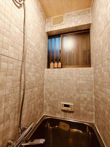a bathroom with a sink and a bath tub at Leisureyado USJ 5 min train 悦宿西九条 in Osaka