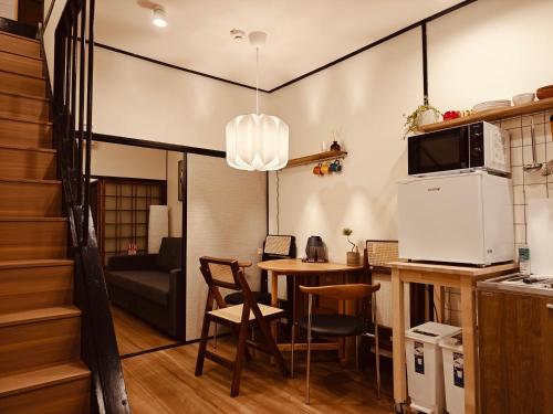 a small kitchen and dining room with a table at Leisureyado 悦宿 USJ 西九条 in Osaka