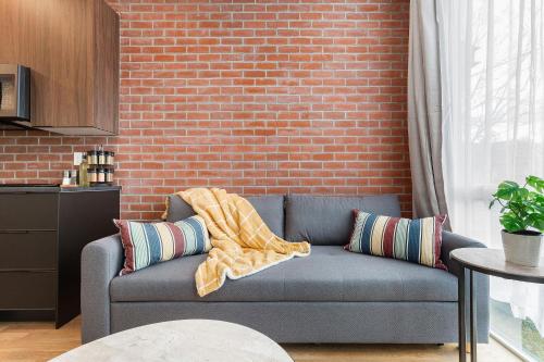 a blue couch in a room with a brick wall at Perch - Marion Manor 16 in Seattle