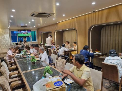 a group of people sitting at tables in a restaurant at The AVR Hotels & Banquets in Patna