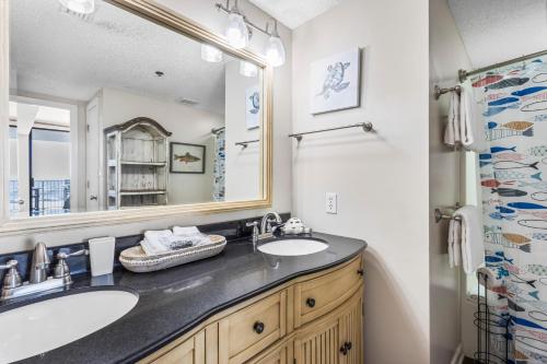 a bathroom with two sinks and a large mirror at Shoalwater 703 by Liquid Life in Orange Beach