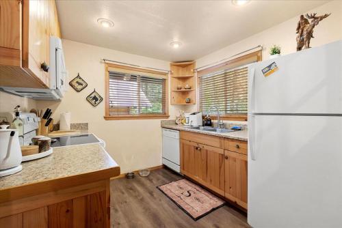 a kitchen with a white refrigerator and wooden cabinets at Perch - Antler House in Ashford