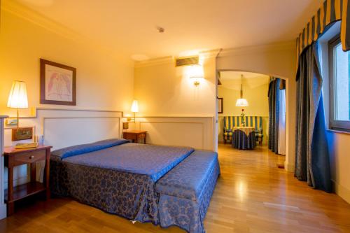 a bedroom with a blue bed in a room at Hotel Casale in Colli del Tronto