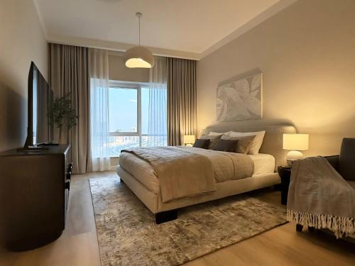 a bedroom with a bed and a large window at Signature Studio JLT in Dubai