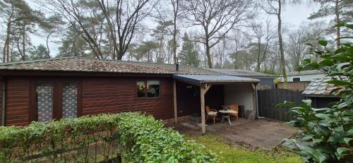 a small house with a porch and a patio at Chalet Hoenderloo Spar in Hoenderloo