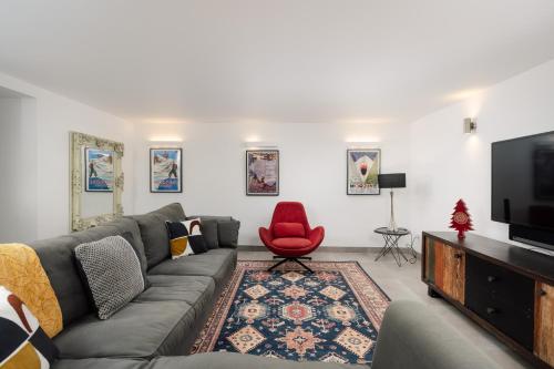 - un salon avec un canapé et un fauteuil rouge dans l'établissement Chalet Vogue, à Morzine